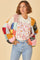 woman wearing a colorful oversized knitted cardigan over a graphic t-shirt with floral print and high-waisted jeans