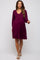 woman wearing a deep purple maternity dress with a v-neck and long sleeves, showing her baby bump