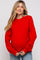 woman wearing a red oversized maternity sweater with long sleeves and a visible baby bump