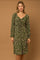 woman wearing a green floral long sleeve dress with a ruched front and a fitted waist