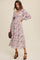 woman wearing a floral print long sleeve wrap dress with a deep V-neck and ruffled details