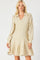 woman wearing a shimmery beige long sleeve wrap dress with a collar and flared skirt