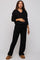 woman wearing a black maternity loungewear set with a v-neck top and wide-leg pants, holding her baby bump