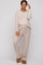 woman wearing a beige maternity ribbed lounge set with a v-neck top and wide-leg pants, styled casually with glasses