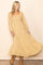 woman wearing a yellow floral puff sleeve maxi dress with a smocked bodice and flowy skirt