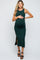 woman wearing a dark green ribbed maternity dress with a side slit and holding her baby bump