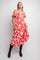 woman wearing a red floral midi dress with short sleeves and a tiered hem, paired with black knee-high boots