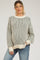 woman wearing a striped maternity sweater in green and cream with a relaxed fit and oversized sleeves