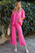 woman wearing a bright pink oversized t-shirt and matching wide-leg pants, standing outdoors with greenery in the background