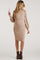woman wearing a beige ribbed maternity dress with puff sleeves and a fitted silhouette, showing her baby bump