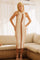 woman wearing a white and brown striped knit midi dress with a halter neckline, standing on a sofa in soft lighting