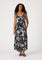 woman wearing a black floral maxi dress with ruffled straps and side pockets