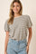woman wearing a cream and navy striped short sleeve top with a relaxed fit and smiling