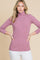 woman wearing a lavender long sleeve turtleneck top paired with white pants