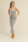 woman wearing a grey ribbed crop top and matching midi skirt with a side slit