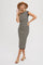 woman wearing a black and beige striped midi dress with cap sleeves and side slits, accessorized with a tan hat and sandals