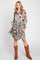 woman wearing a teal floral shirt dress with long sleeves and brown cowboy boots