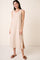 woman wearing a beige sleeveless maxi dress with side slits and brown slide sandals