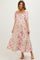woman wearing a floral maternity dress with puff sleeves and a tiered skirt, showcasing a baby bump