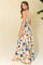 woman wearing a bohemian-style maxi dress with a colorful animal print and open back design