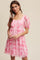 woman wearing a pink floral puff sleeve dress with a square neckline and gathered waist