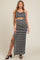 woman wearing a black and white patterned maternity maxi dress with a side slit and a fitted bodice