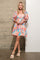 woman wearing a colorful short puff sleeve dress with a fitted waist and flared skirt