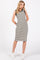woman wearing a black and white striped sleeveless dress with side pockets and white sneakers