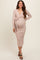 woman wearing a light pink long sleeve maternity dress with a wrap tie and a visible baby bump