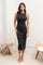 woman wearing a black sleeveless midi dress with a fitted silhouette and strappy high-heeled sandals