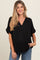 woman wearing a black maternity top with a v-neck and rolled sleeves, highlighting her baby bump