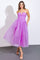 woman wearing a strapless lavender midi dress with a fitted bodice and flowing tulle skirt