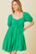 woman wearing a green puff sleeve mini dress with a square neckline and gathered waist.