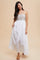 woman wearing a white maxi dress with floral embroidery on the bodice and thin spaghetti straps