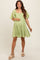 woman wearing a light green maternity dress with short flutter sleeves and a square neckline, showcasing her baby bump