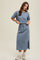 woman wearing a blue midi t-shirt dress with short sleeves and a drawstring waist, standing with hands at the waist