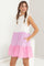 woman wearing a sleeveless white and pink color block dress with ruffle sleeves and pockets