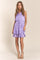 woman wearing a lavender sleeveless tiered dress with a drawstring waist and pockets, standing against a neutral background