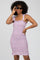 woman with curly hair wearing a purple floral smocked dress and black cat-eye sunglasses