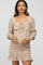 woman wearing a beige square neck maternity dress with floral print and ruffles, showcasing her baby bump