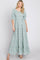 woman wearing a sage green floral print tiered maxi dress with puff sleeves and smocked bodice