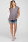 pregnant woman wearing floral maternity top and denim shorts with white sandals