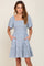 woman wearing a light blue floral smocked mini dress with puff sleeves and pockets