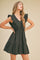 Woman wearing a black sleeveless ruffle mini dress with a v-neckline and tiered skirt