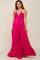 woman wearing a hot pink pleated halter neck maternity maxi dress