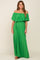 woman wearing a green off-the-shoulder pleated maternity maxi dress with a ruffled neckline