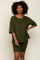 Woman wearing an olive green ribbed lounge set featuring an oversized pocket tee and matching biker shorts