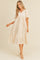 woman wearing a cream puff sleeve midi babydoll dress with a v-neckline and ruffled hem