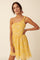 woman wearing a yellow one-shoulder dress with a ruched bodice and floral pattern