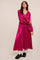 woman wearing a bright pink satin midi dress with long puff sleeves and lace details